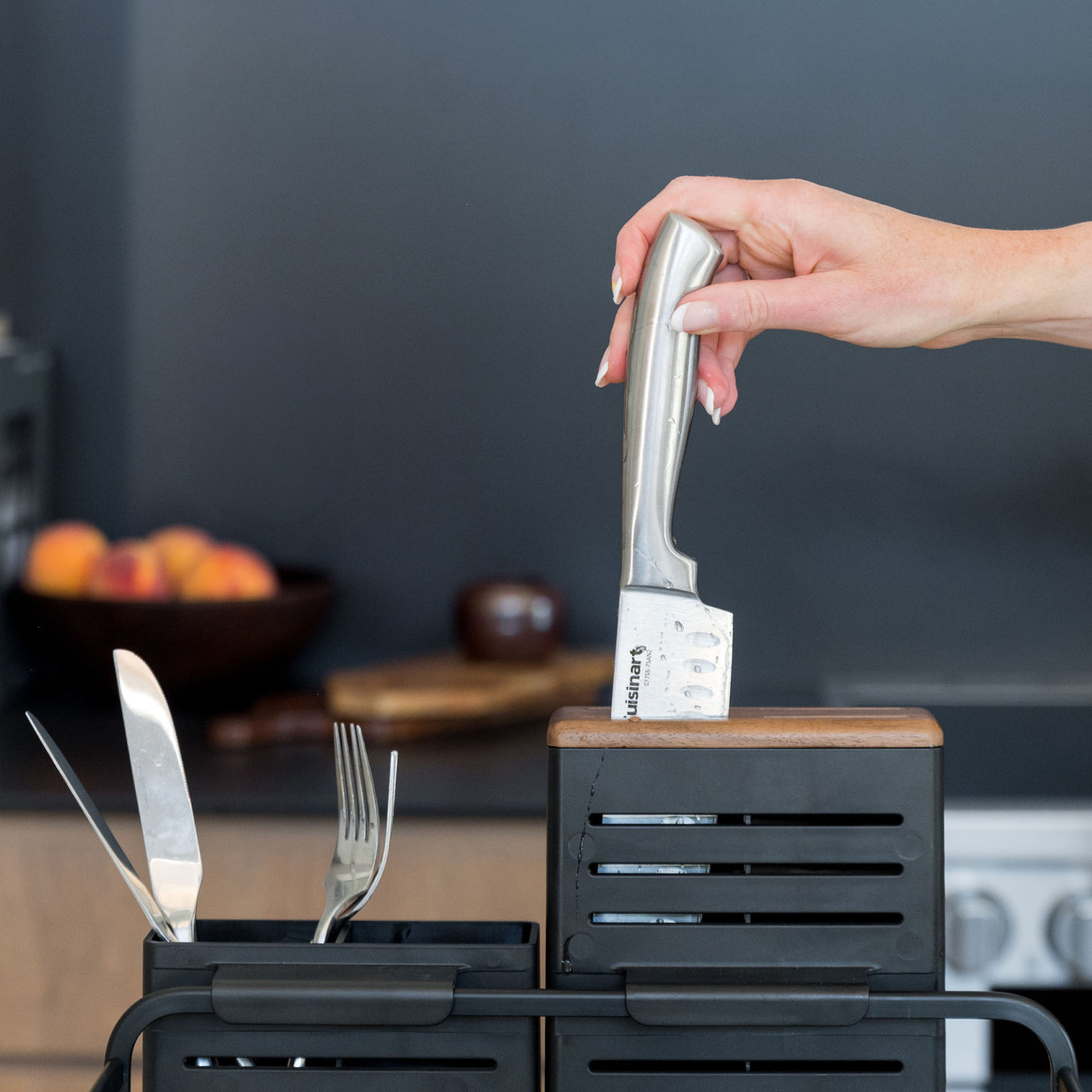 Placing a knife in the holder of a modern basalt dish rack.