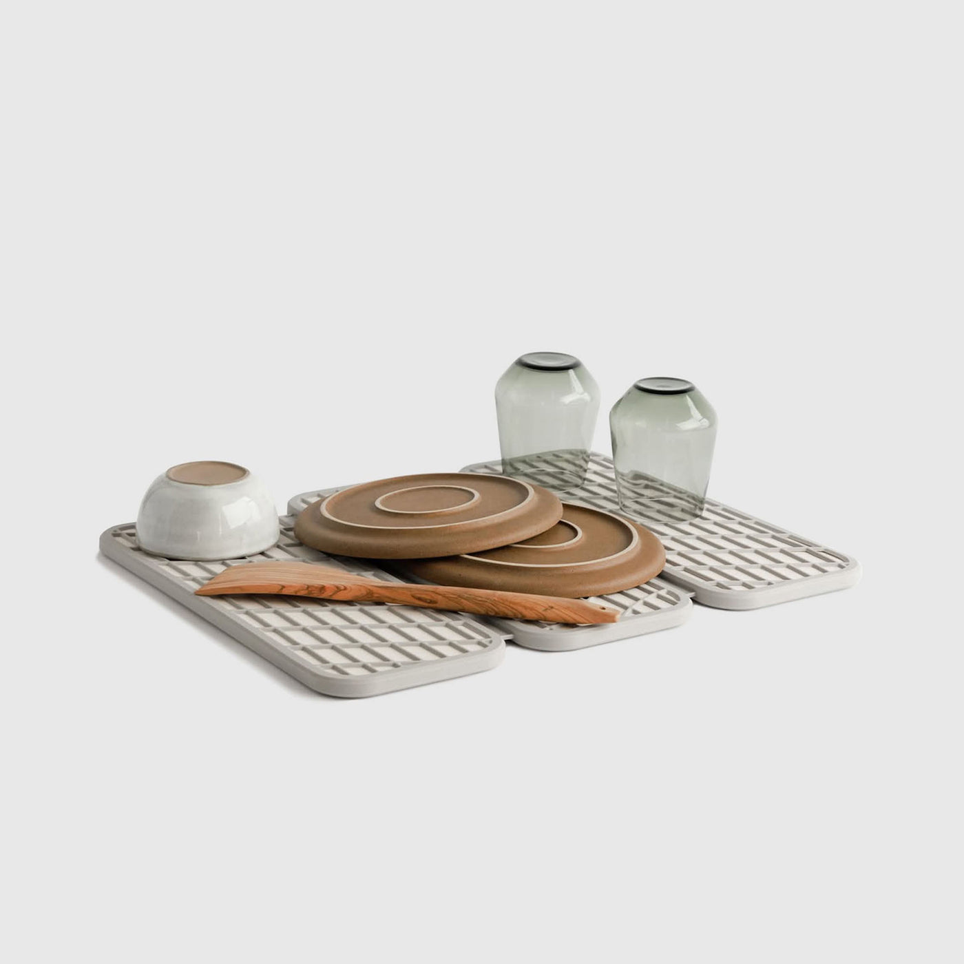 Drift Sandstone Dish Pad with plates and glasses on white background.