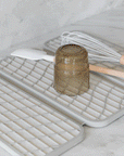 gif of sandstone dish pad with wet cup being removed from it