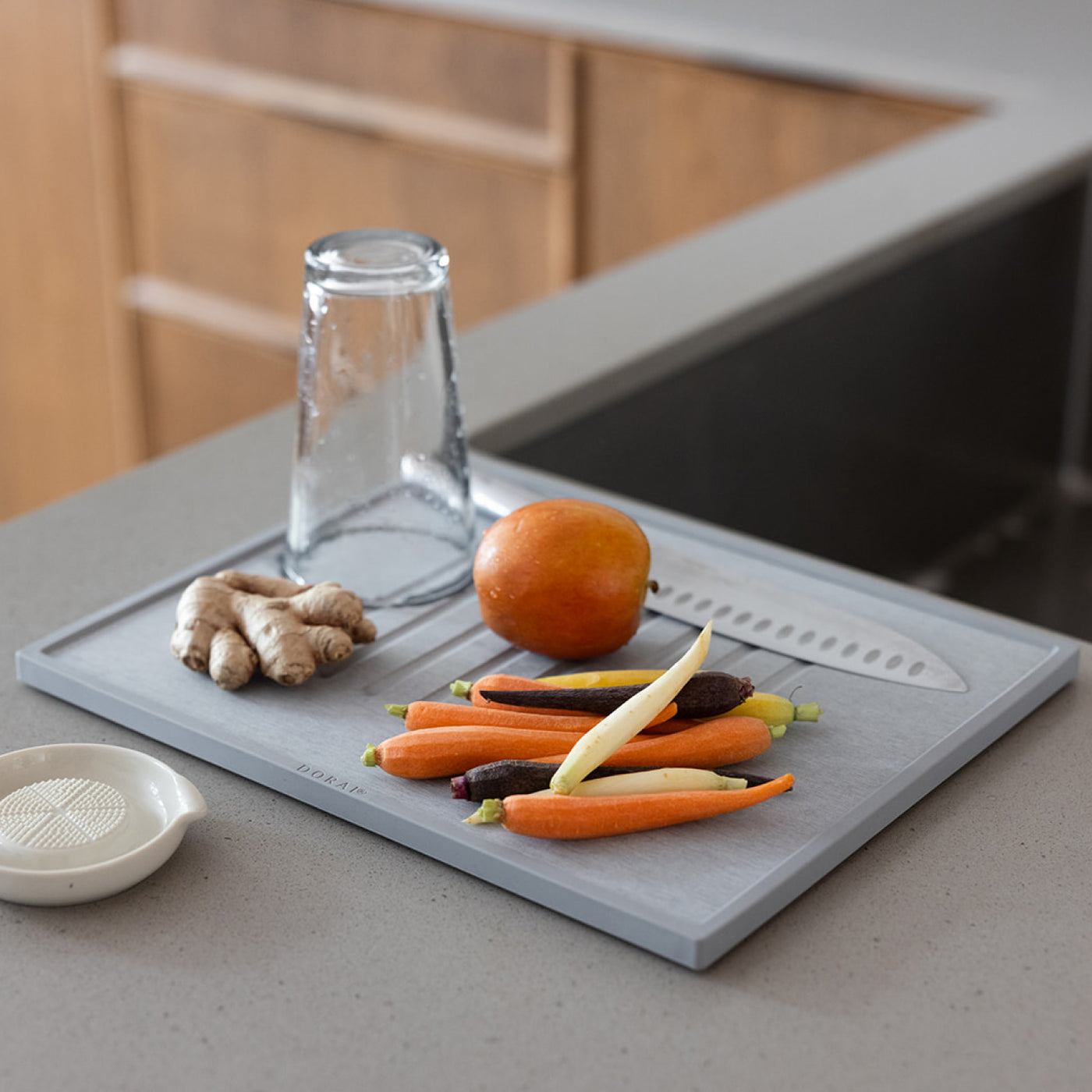 Gray dish drying mat with vegetables and a knife on a kitchen counter