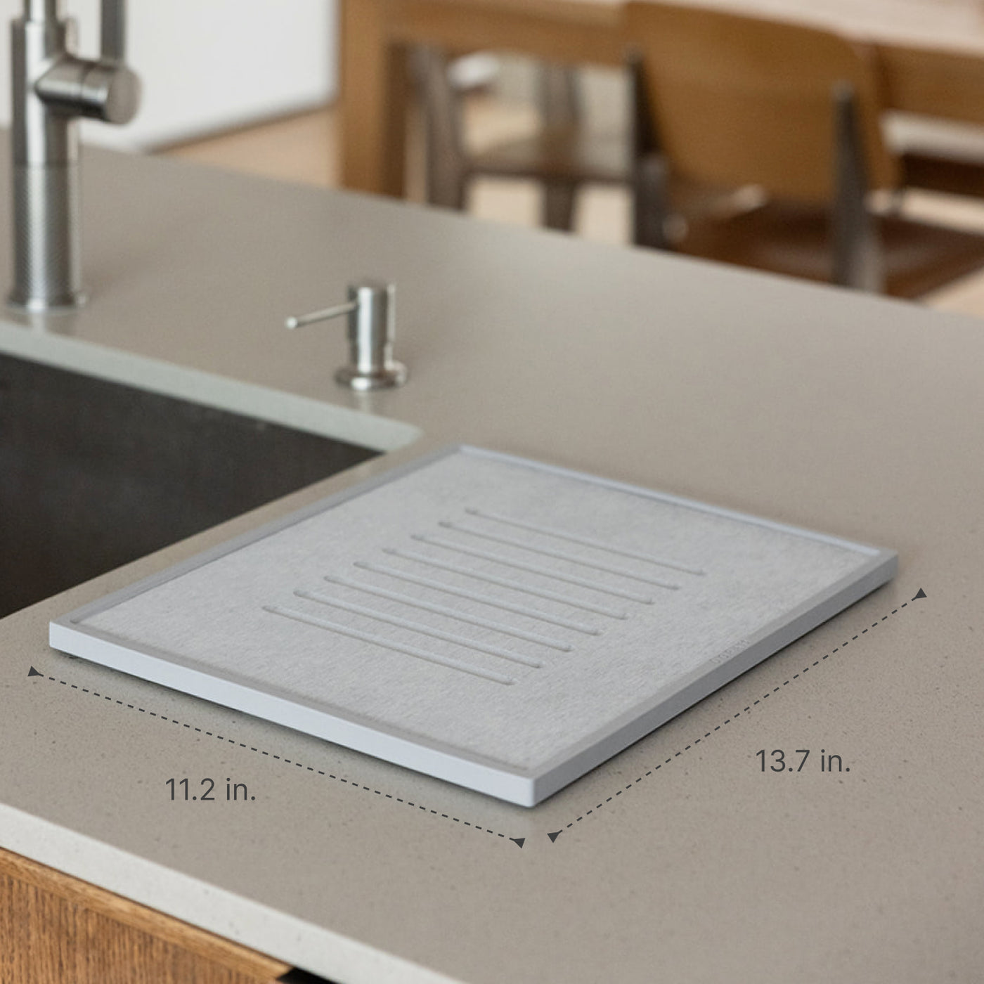 Gray dish drying mat on a kitchen counter with measurements indicated