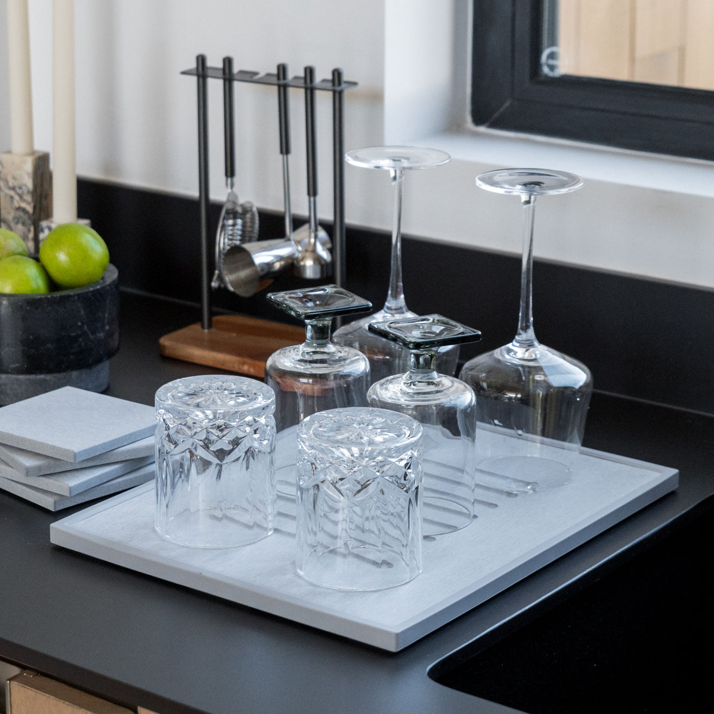 Beautiful bar glasses in modern kitchen on ash dish pad.