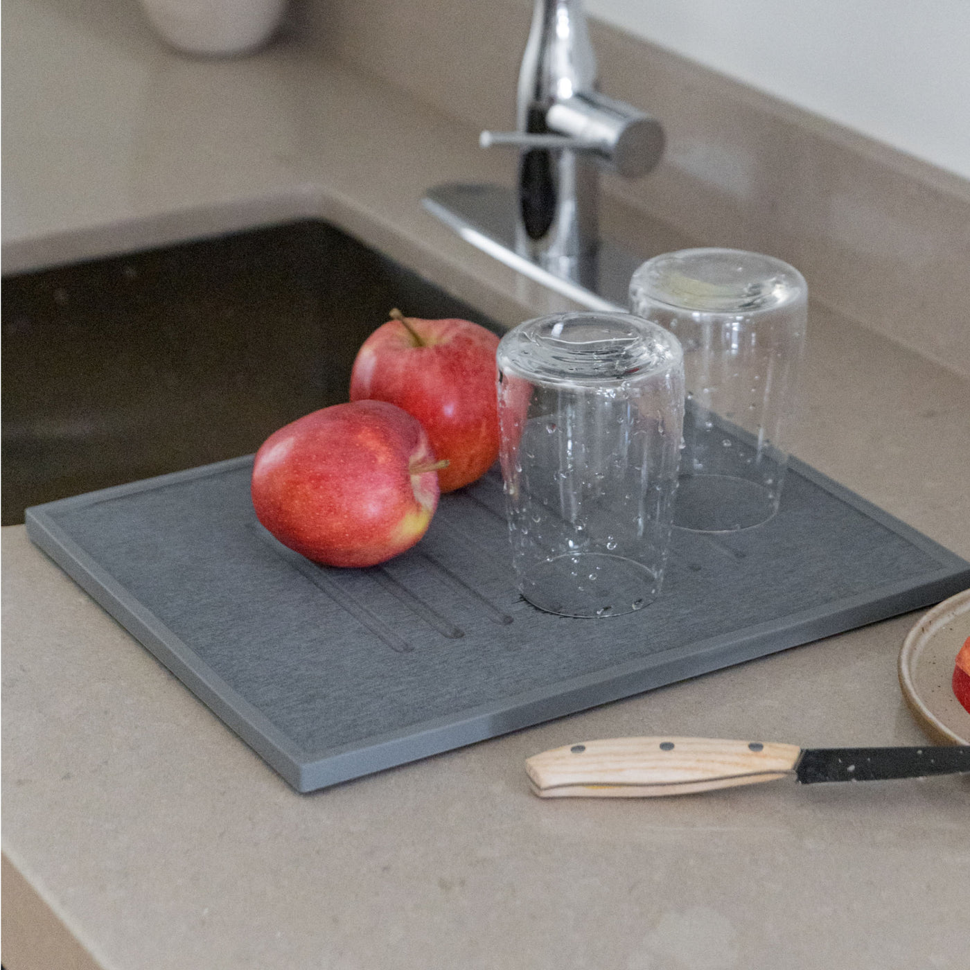 Slate quick-drying dish stone with apples and glasses for modern kitchen. 