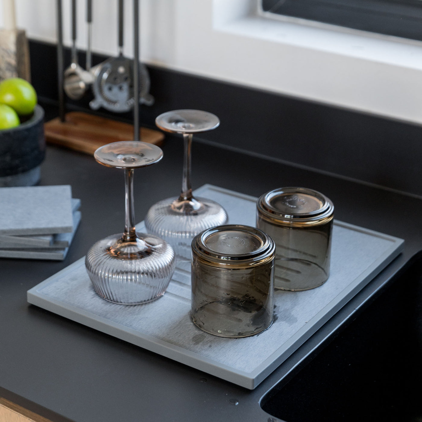 Beautiful bar glasses in modern kitchen on slate dish pad.