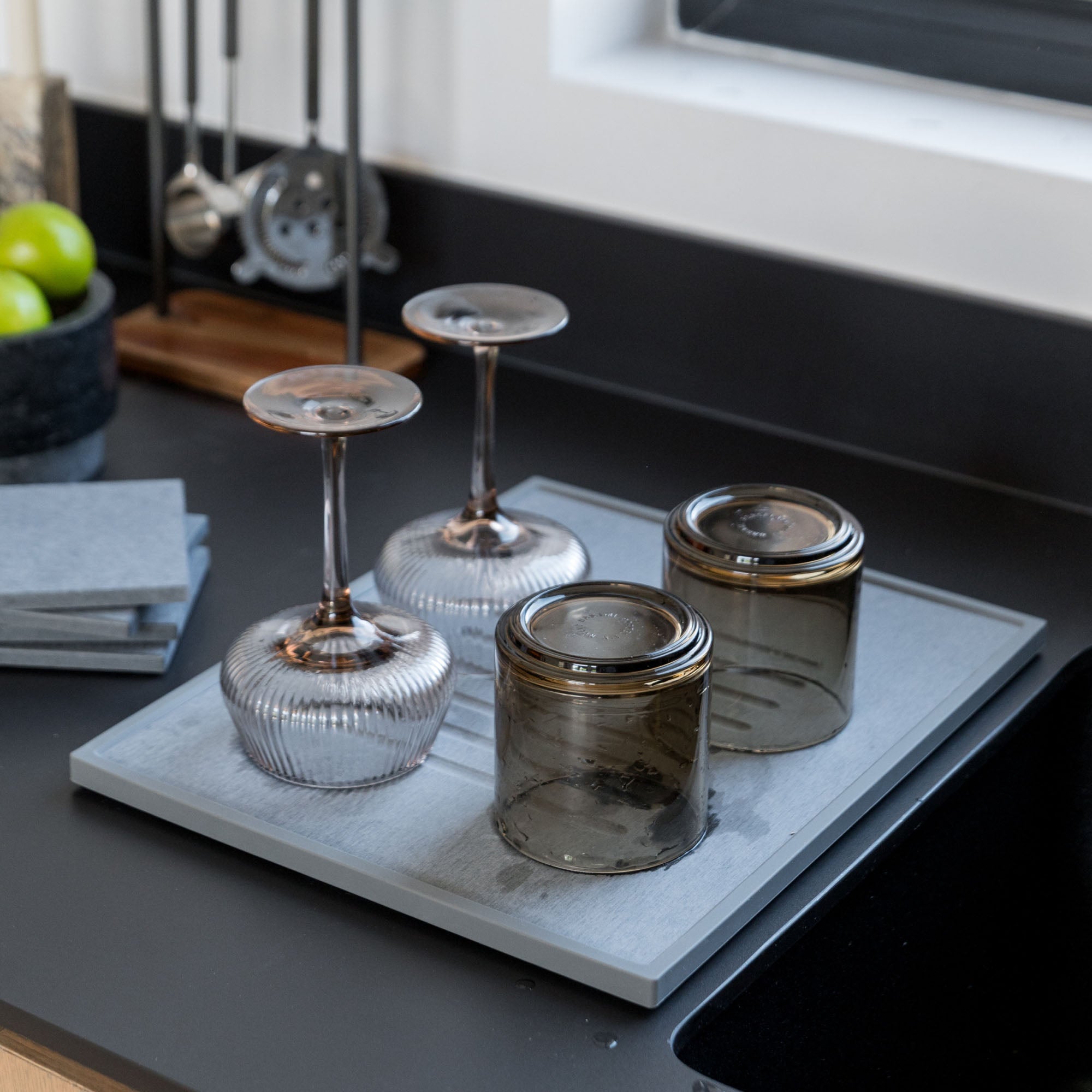 Beautiful bar glasses in modern kitchen on slate dish pad.