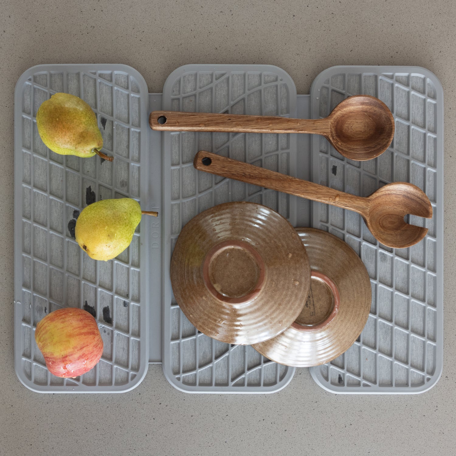 light grey dish pad with wooden spoons and dishes