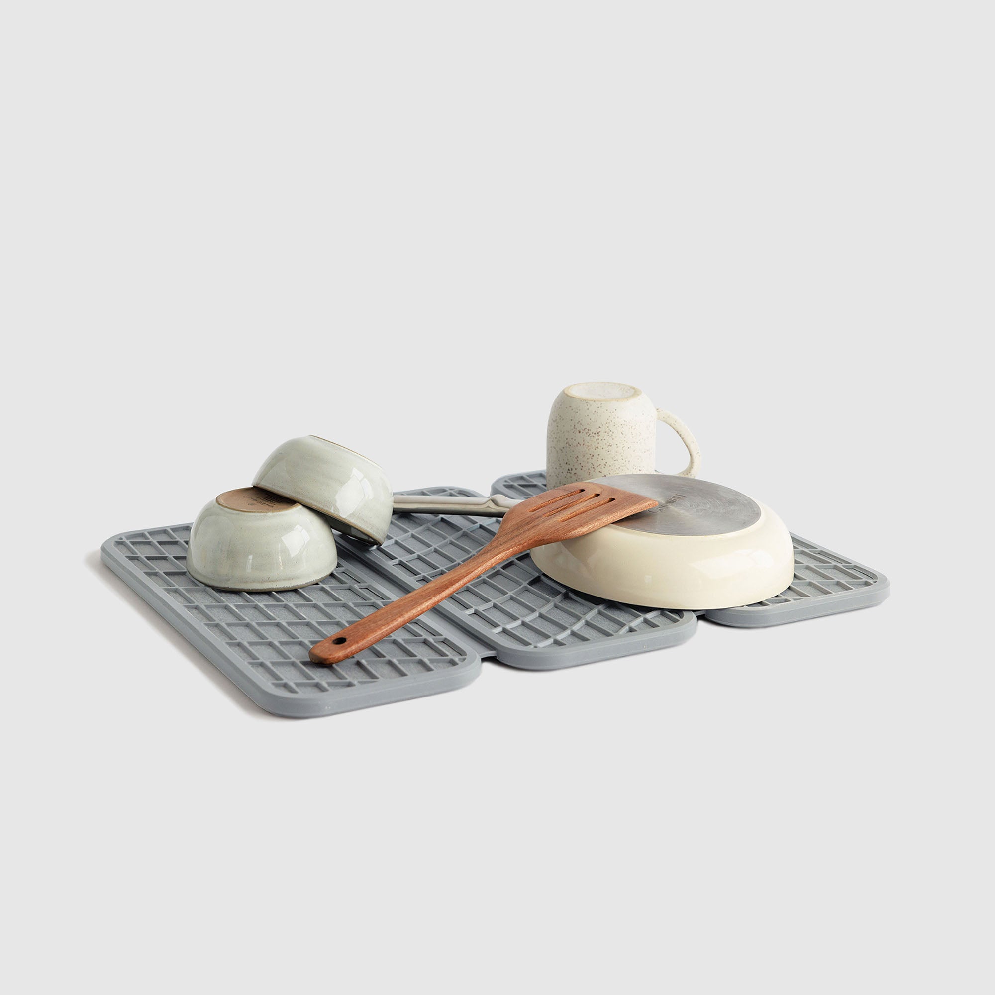 Drift Ash Dish Pad with plates and cups on white background.
