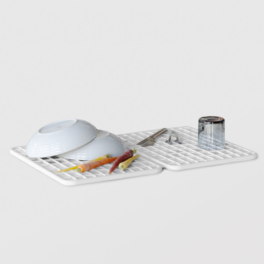 white dish pad with dishes and vegetables on white background