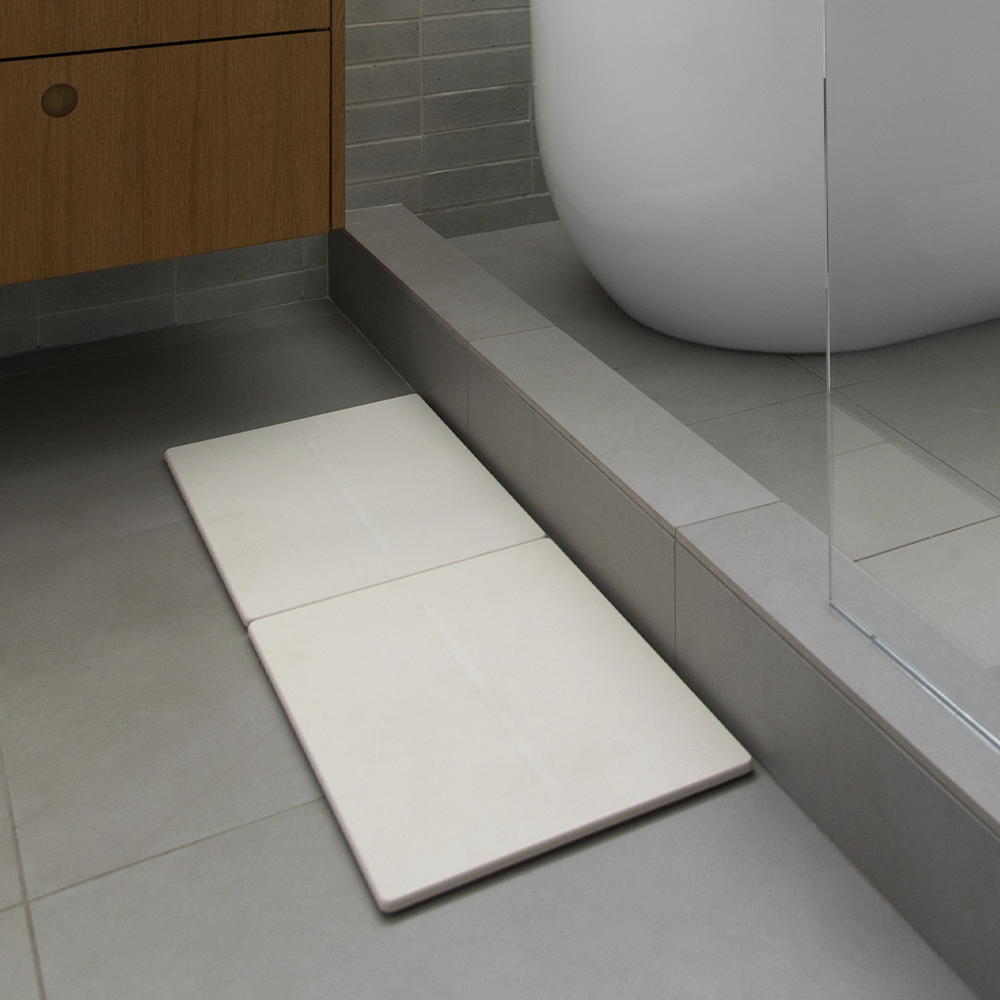 Adjusting the tiles of the Dual Bath Stone™ Mat to fit your space.