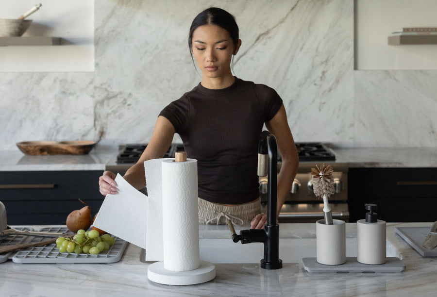 modern paper towel holder with model pulling one sheet of paper towel by one hand