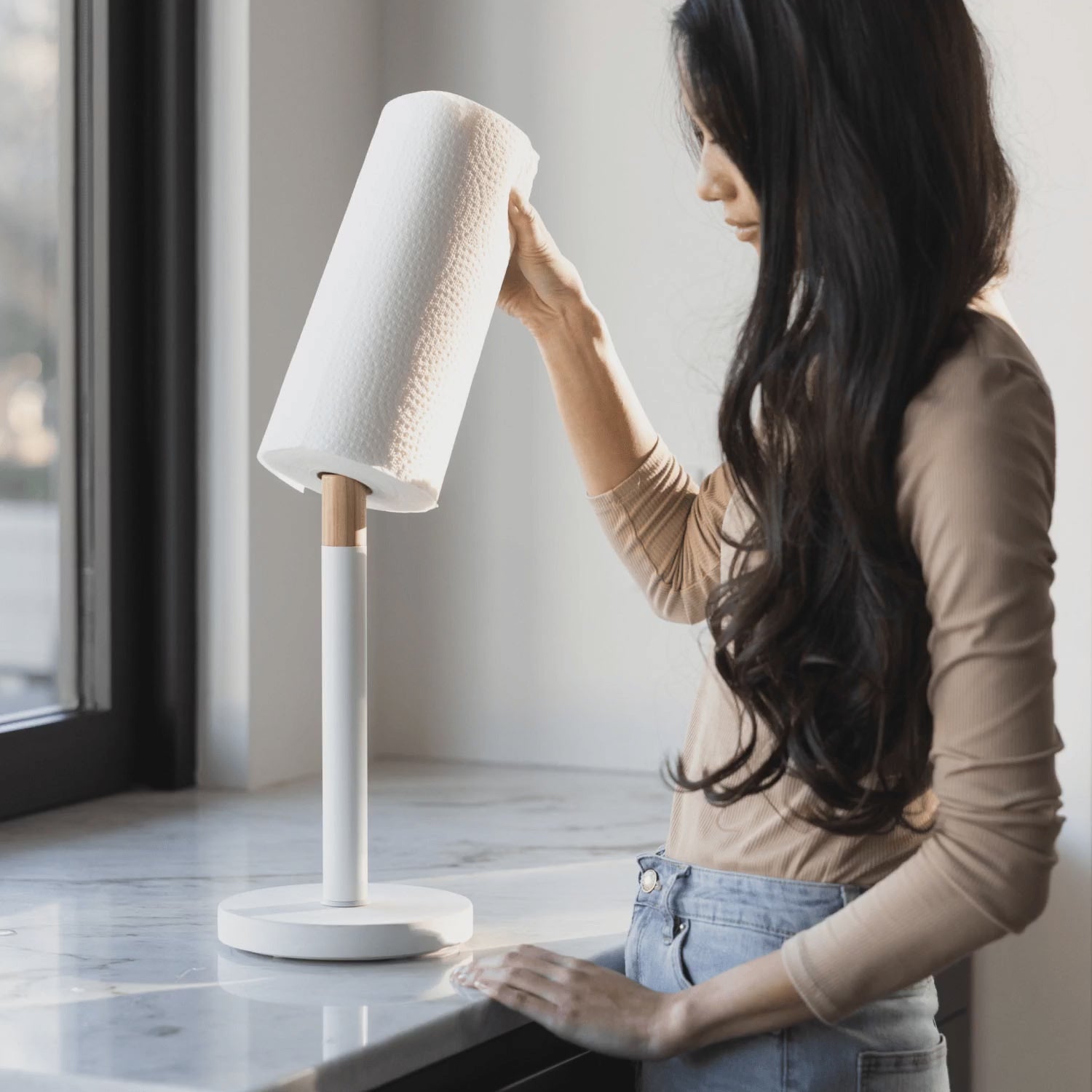 woman inserting paper towels on paper towel holder with stone base for quick drying