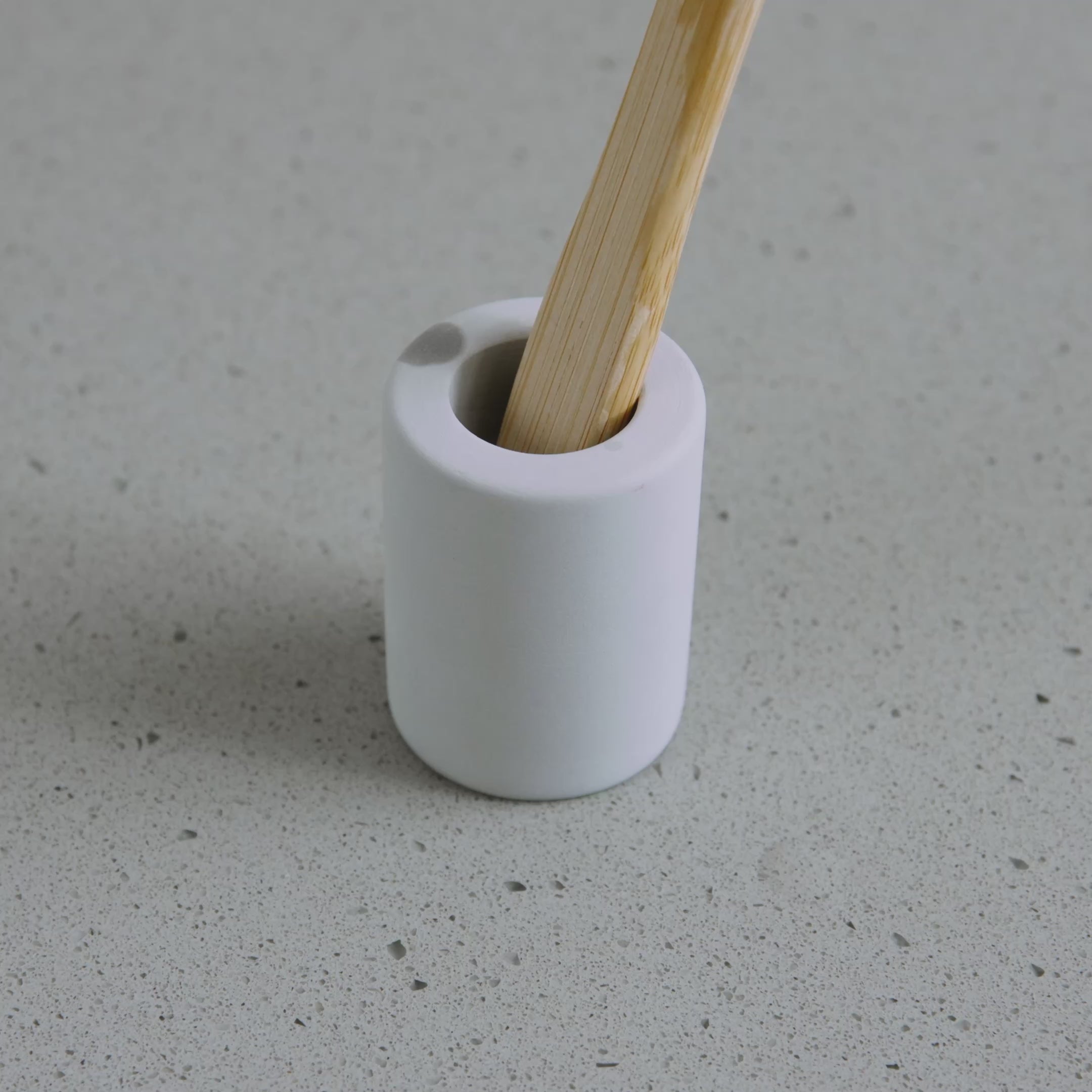 Small, light gray tooth brush holder quickly dries moisture. 