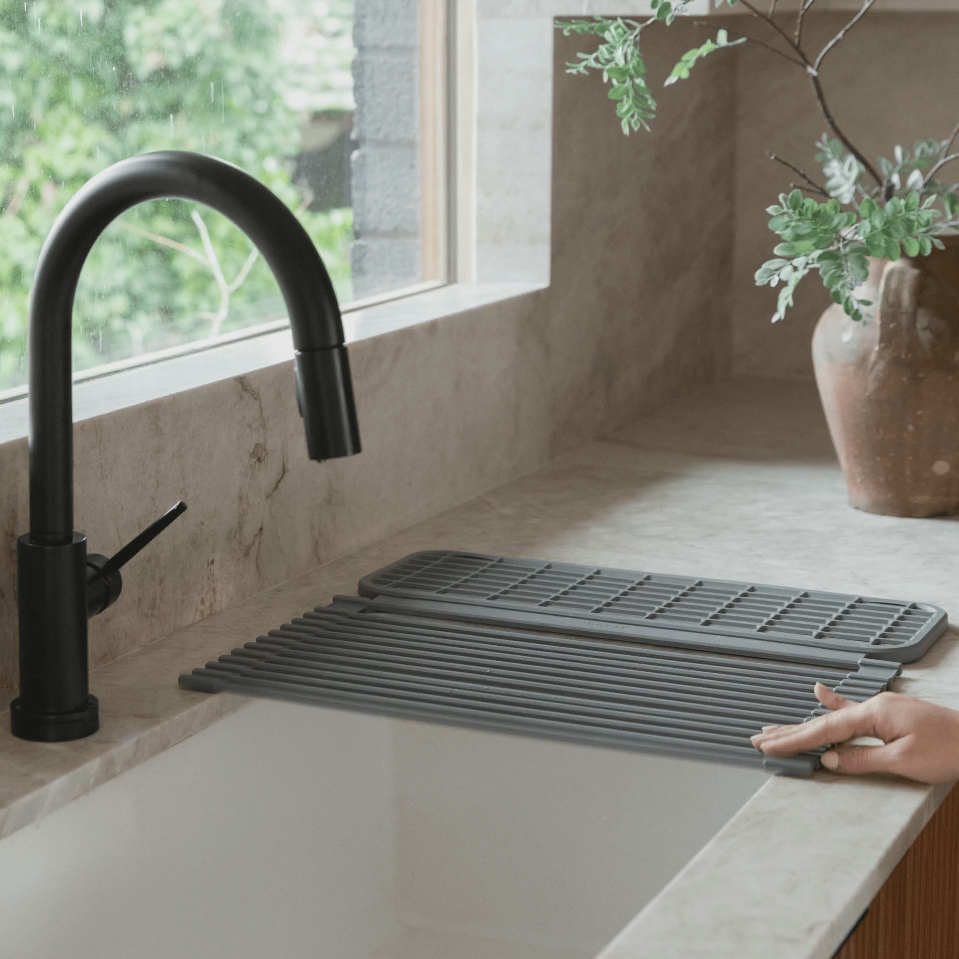 video of woman unrolling a dish pad over her kitchen sink