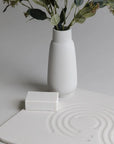sandstone zen bath stone mat with a vase and plants and soap