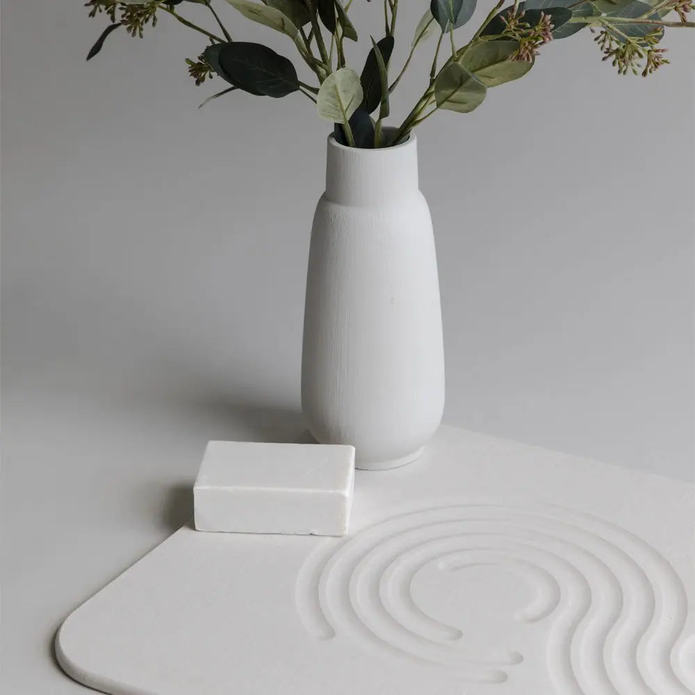 sandstone zen bath stone mat with a vase and plants and soap